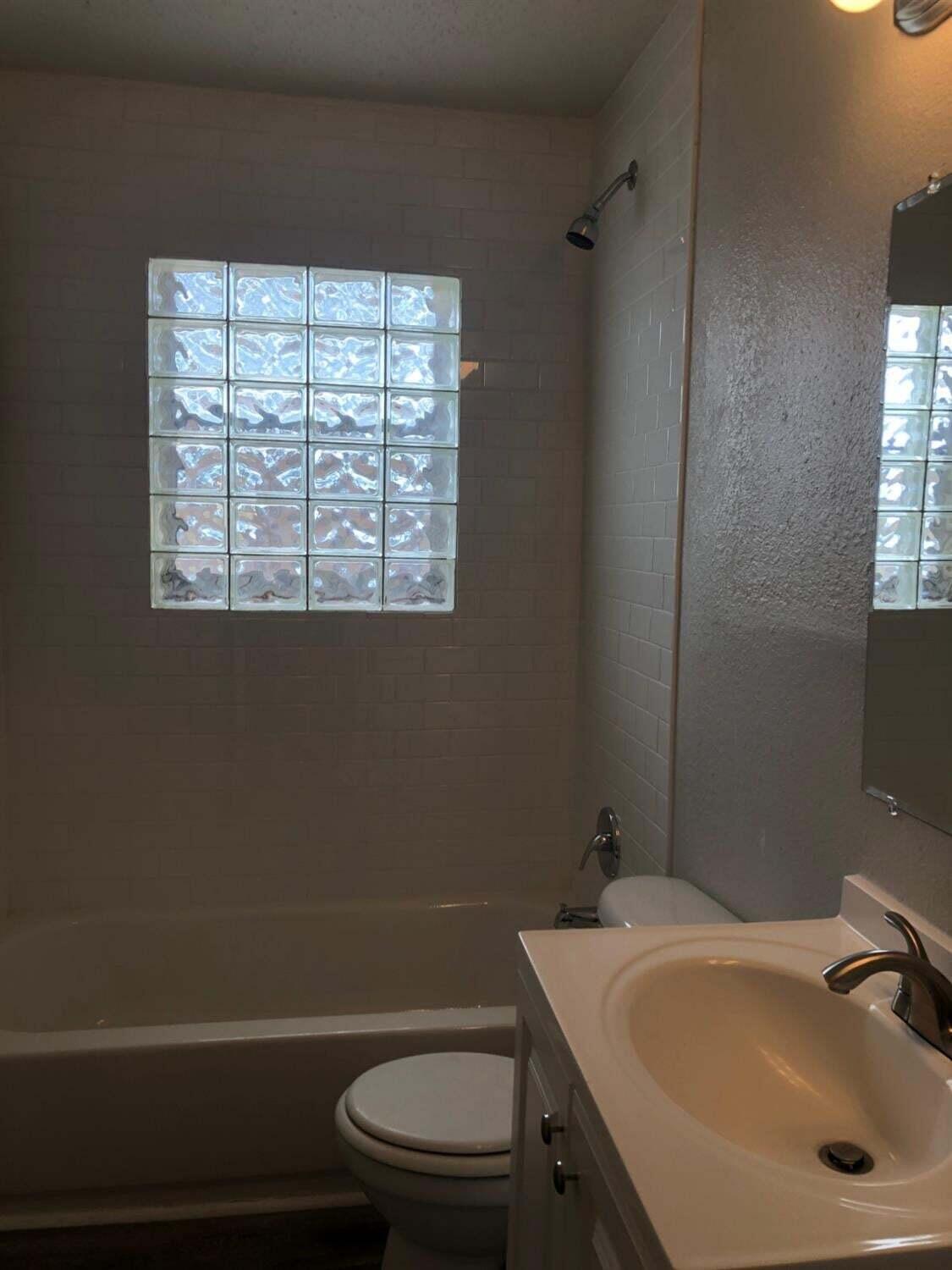 4401 31st Street Lubbock, TX 79410 - Photo 7 of 21 a bathroom with a sink a toilet and a window