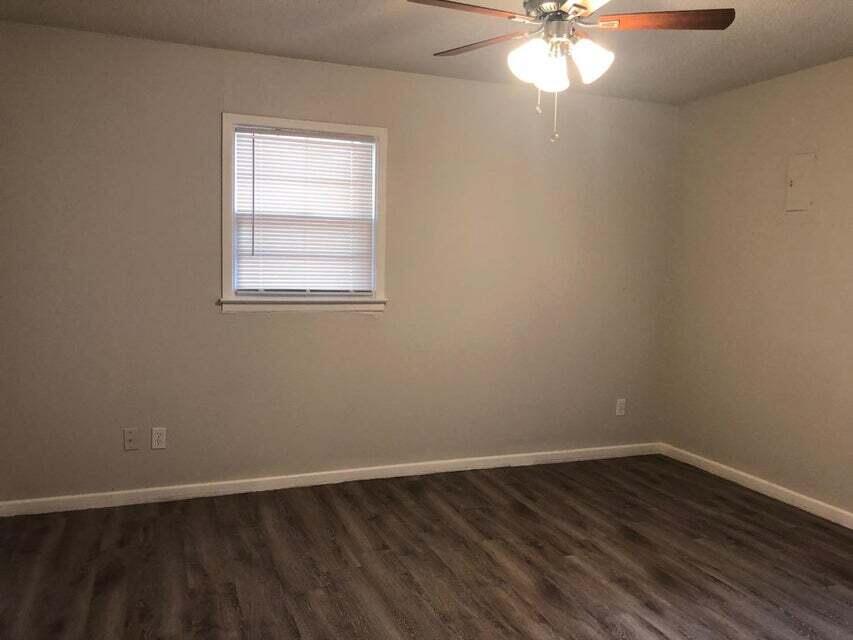 4401 31st Street Lubbock, TX 79410 - Photo 8 of 21 a view of an empty room with wooden floor and a window