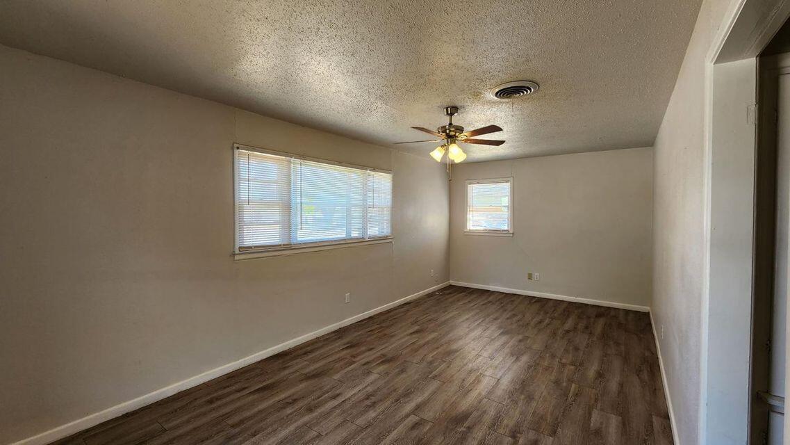 4401 31st Street Lubbock, TX 79410 - Photo 10 of 21 a view of an empty room with wooden floor and a window