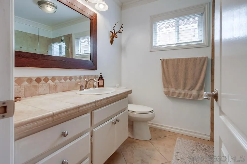 1846 Olympus Loop Drive Vista, CA 92081 - Photo 25 of 34 a bathroom with a toilet sink and mirror