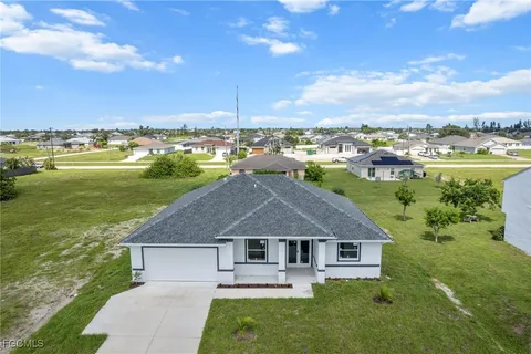 a aerial view of a house with a garden and lake view
