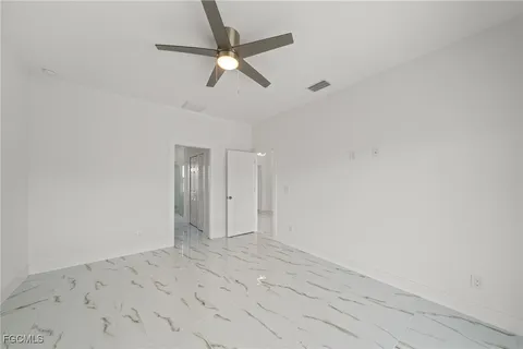 an empty room with a fan and a window