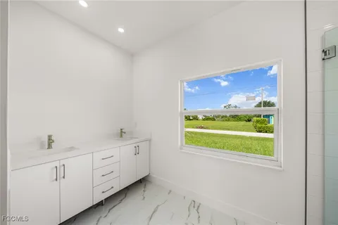 a bathroom with a sink mirror and window