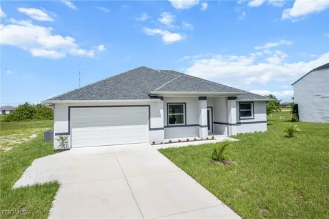 a front view of a house with a garden and yard