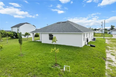 a backyard of a house with plants and palm tree