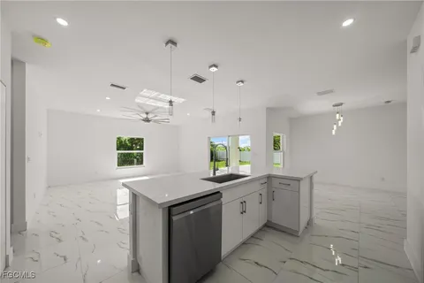 a kitchen with a sink chandelier and stove