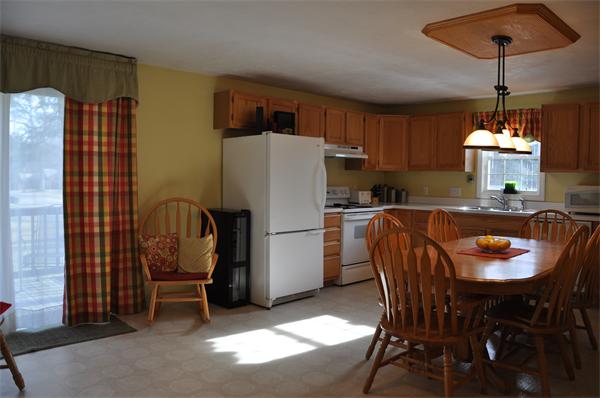24 1/2 Mason Road Dudley, MA 01571 - Photo 3 of 30 a kitchen with a refrigerator a table and chairs
