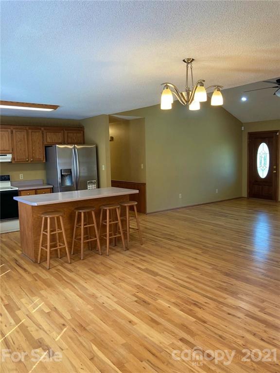 1091 South Beersheba Road Clover, SC 29710 - Photo 9 of 23 a kitchen with stainless steel appliances kitchen island granite countertop a table chairs and a wooden floor