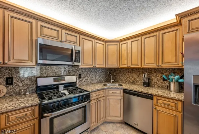 a kitchen with stainless steel appliances granite countertop a stove microwave sink and cabinets