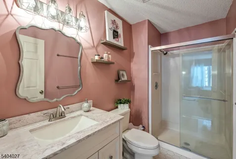 a bathroom with a granite countertop sink toilet and shower