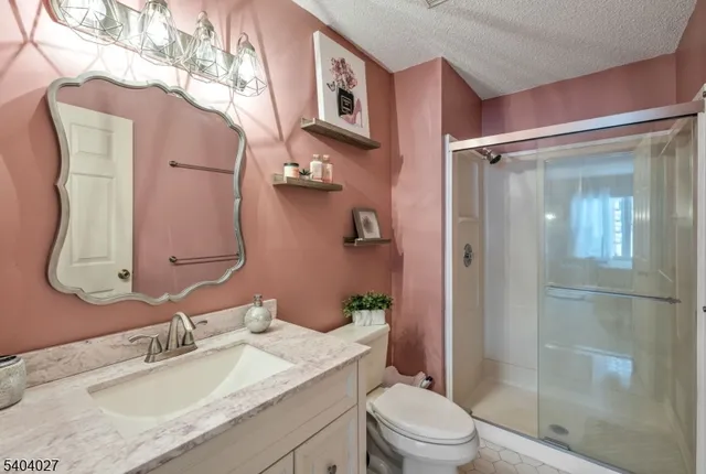 a bathroom with a granite countertop sink toilet and shower