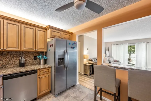 a kitchen with stainless steel appliances granite countertop a refrigerator a sink a stove and island