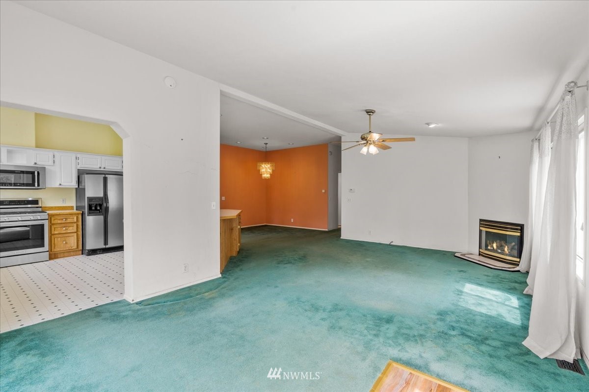 17455 Allen Road Bow, WA 98232 - Photo 13 of 33 a view of a kitchen with a sink cabinet a fireplace and a workspace