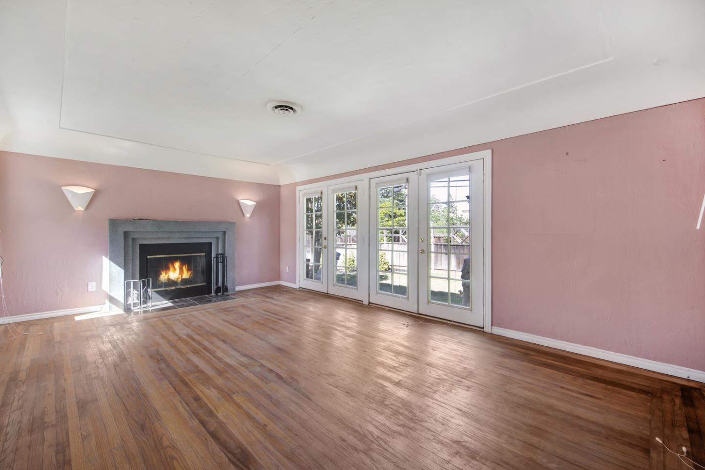 1265 Burrows Road Campbell, CA 95008 - Photo 7 of 32 a view of an empty room with wooden floor fireplace and a window