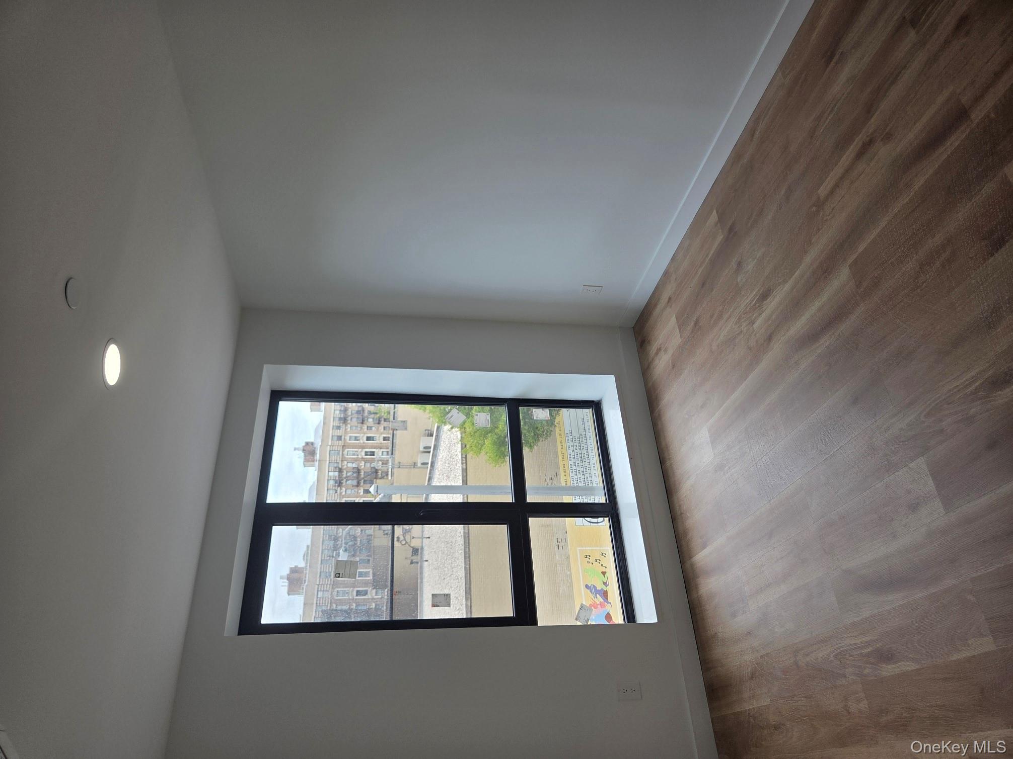 132 West 134th Street Manhattan, NY 10030 - Photo 11 of 15 a view of an empty room with wooden floor and a window