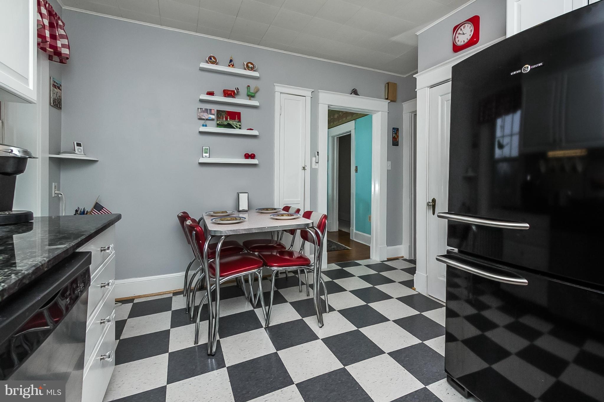 238 Ridgeway Road Baltimore, MD 21228 - Photo 18 of 30 a room with a black white checkered floor and a dining table with wooden floor