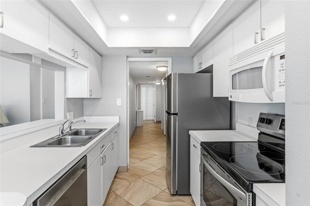 5966 Midnight Pass Road, Unit G113 Sarasota, FL 34242 - Photo 11 of 39 a kitchen with stainless steel appliances granite countertop a sink stove and refrigerator