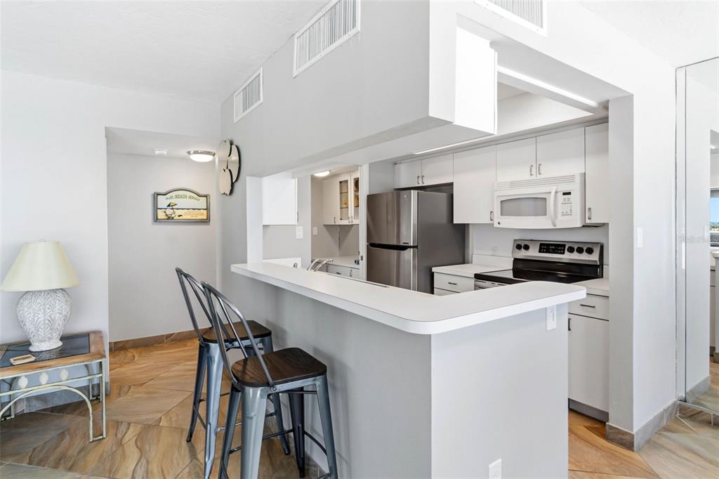 5966 Midnight Pass Road, Unit G113 Sarasota, FL 34242 - Photo 12 of 39 a kitchen view with stainless steel appliances a refrigerator and a stove top oven