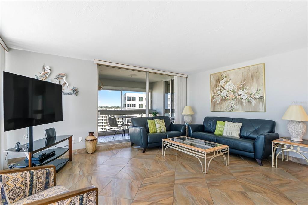 5966 Midnight Pass Road, Unit G113 Sarasota, FL 34242 - Photo 16 of 39 a living room with furniture and a flat screen tv