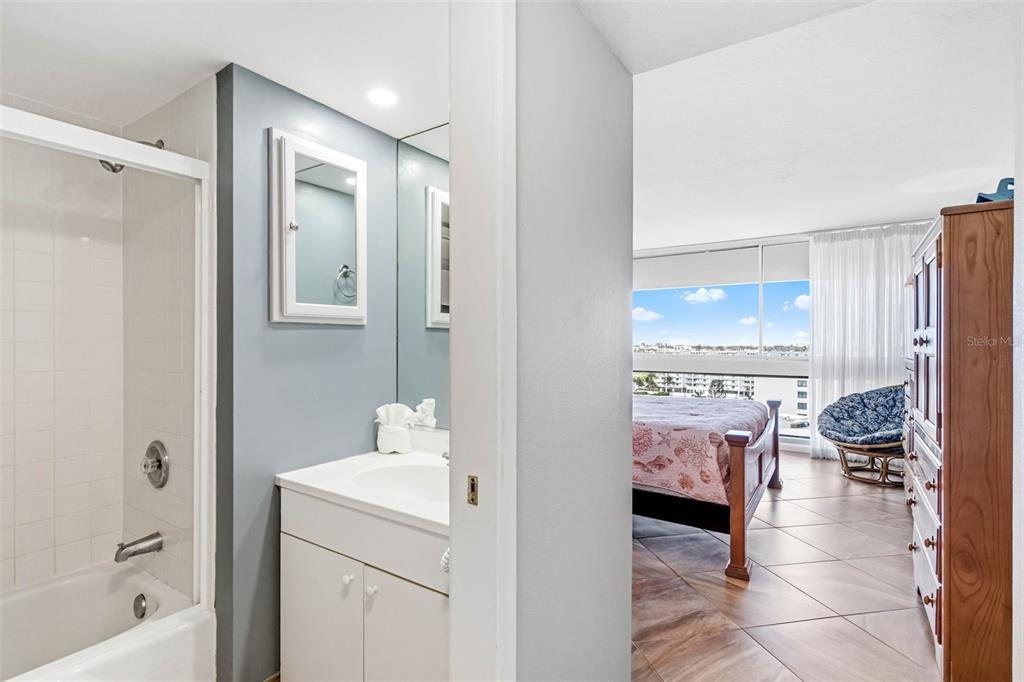 5966 Midnight Pass Road, Unit G113 Sarasota, FL 34242 - Photo 26 of 39 a en suite bathroom with a granite countertop sink a mirror and a bathtub