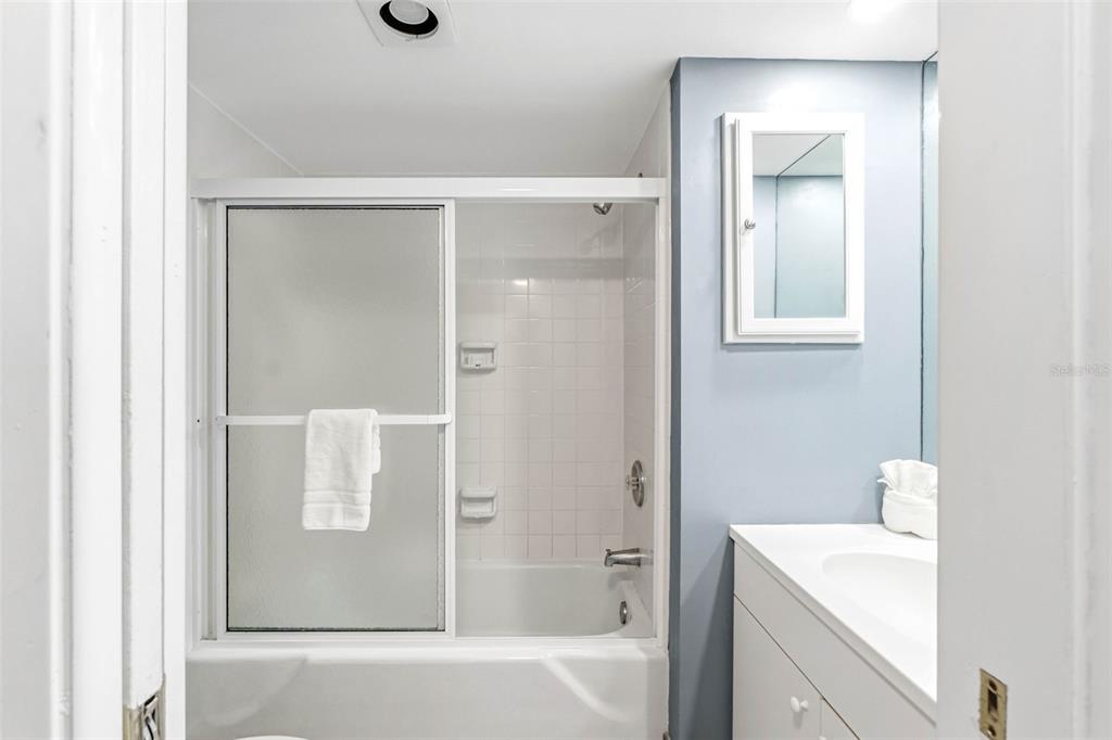 5966 Midnight Pass Road, Unit G113 Sarasota, FL 34242 - Photo 27 of 39 a bathroom with a shower sink and mirror