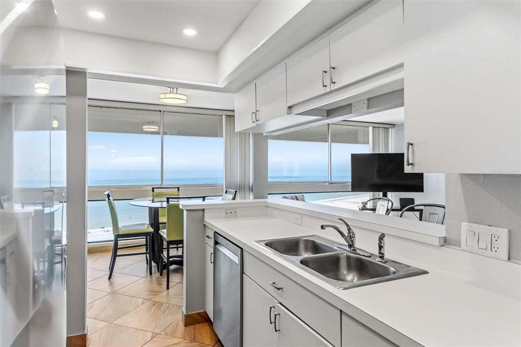 5966 Midnight Pass Road, Unit G113 Sarasota, FL 34242 - Photo 7 of 39 a kitchen that has a sink and chairs