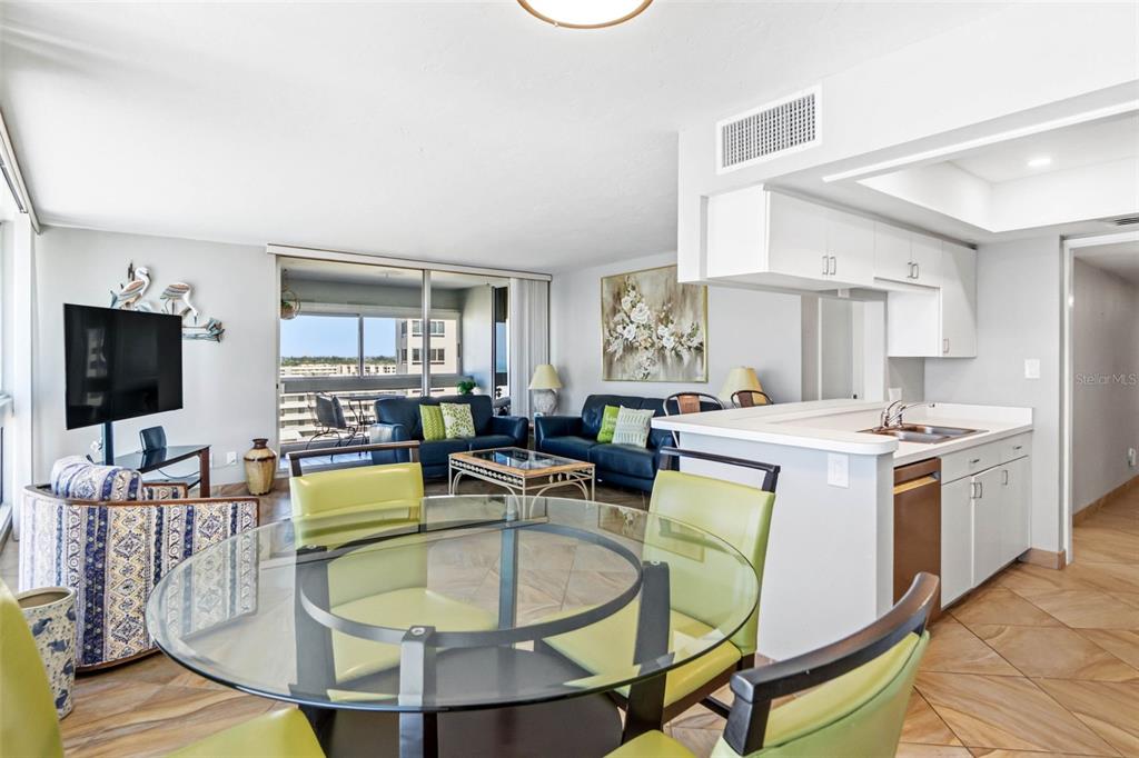 5966 Midnight Pass Road, Unit G113 Sarasota, FL 34242 - Photo 10 of 39 a living room with dining table and a flat screen tv