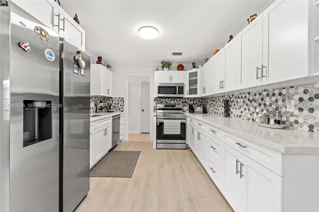 a kitchen with stainless steel appliances kitchen island granite countertop a refrigerator and a stove top oven