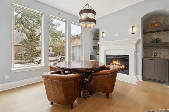 a dining hall with stainless steel appliances kitchen island granite countertop a table chairs and a view of living room