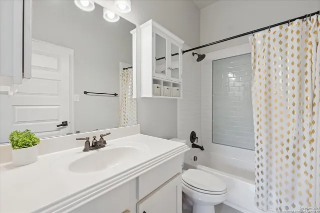 a bathroom with a granite countertop sink a toilet and a shower
