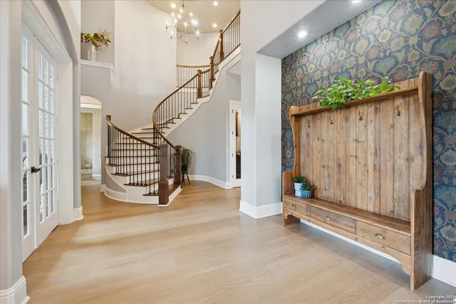 a open kitchen with stainless steel appliances granite countertop a stove top oven a sink dishwasher a dining table and chairs with wooden floor