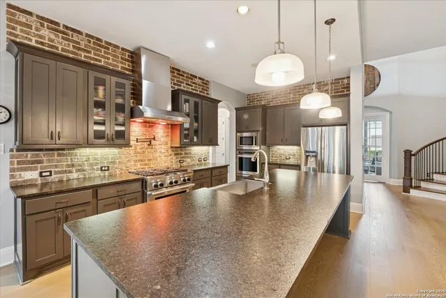 a kitchen with stainless steel appliances kitchen island a large counter top space a sink and appliances