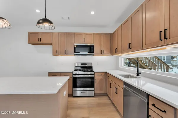 a kitchen with stainless steel appliances granite countertop a sink a stove and a refrigerator