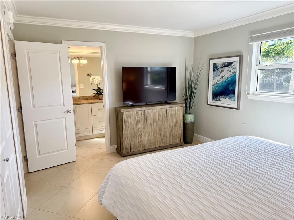 960 7th Street South, Unit 202 Naples, FL 34102 - Photo 12 of 16 a bedroom with a bed and a flat screen tv