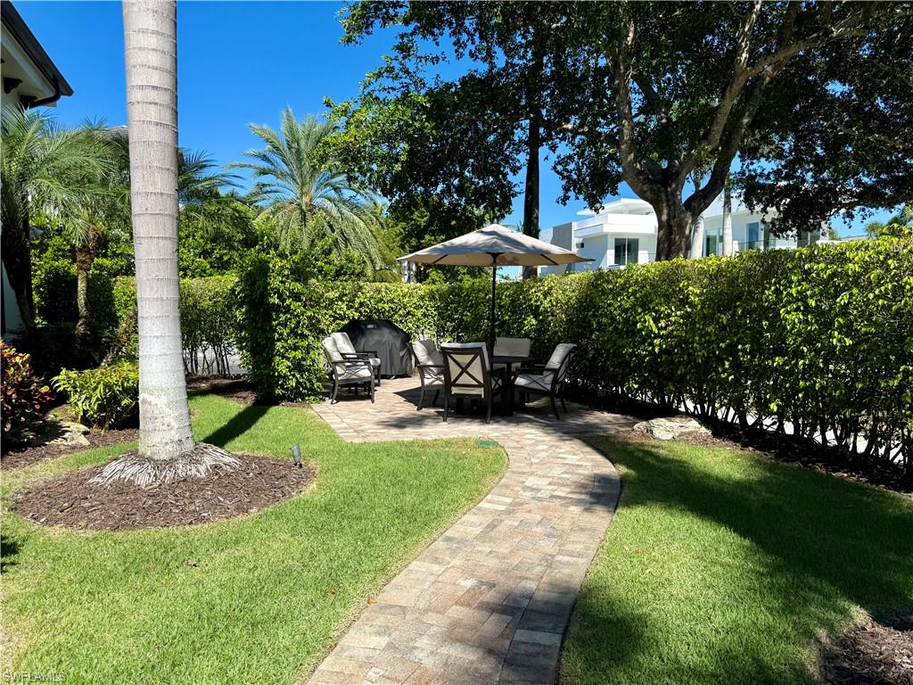 960 7th Street South, Unit 202 Naples, FL 34102 - Photo 14 of 16 a view of a backyard with plants and a patio