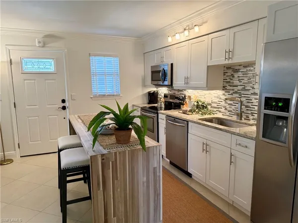 a kitchen with stainless steel appliances a sink a table and chairs
