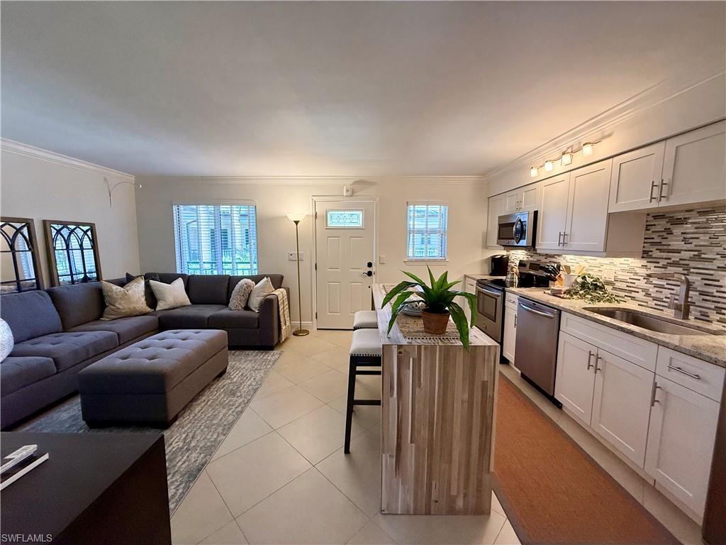 960 7th Street South, Unit 202 Naples, FL 34102 - Photo 6 of 16 a living room with furniture kitchen area and a wooden floor