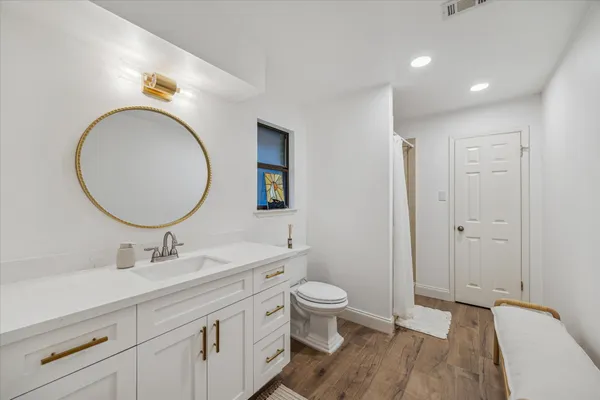 a bathroom with a toilet a sink and a mirror