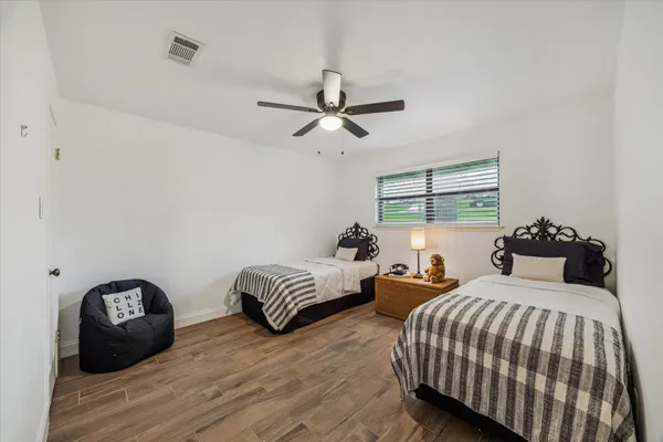 a bedroom with two beds and a chandelier