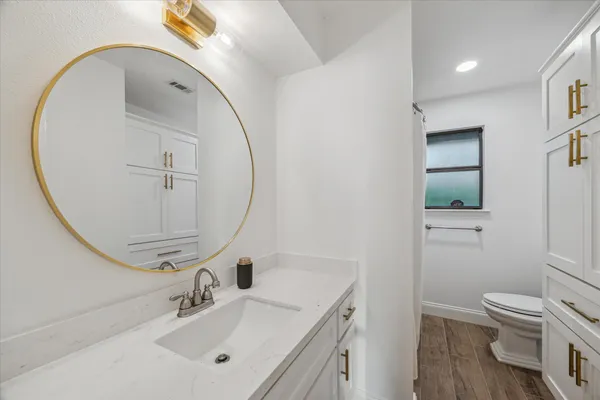 a bathroom with a sink a toilet and shower