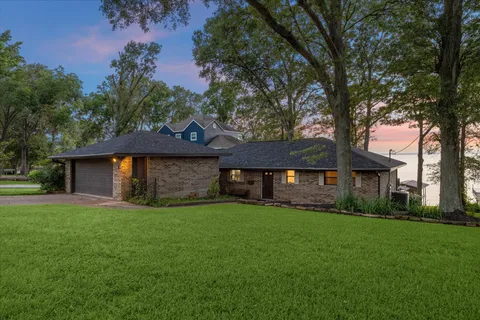 a front view of a house with a yard and trees