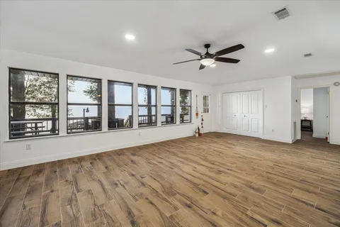 a view of an empty room with a window and a kitchen