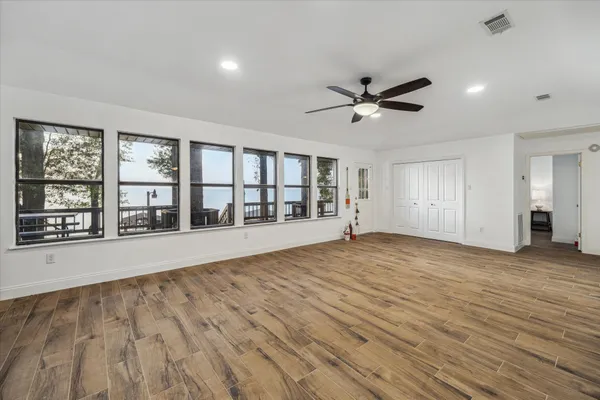 a view of an empty room with a window and a kitchen