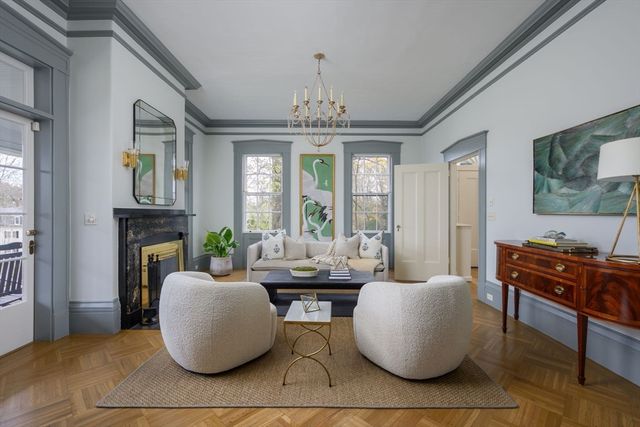 a living room with fireplace furniture and a chandelier