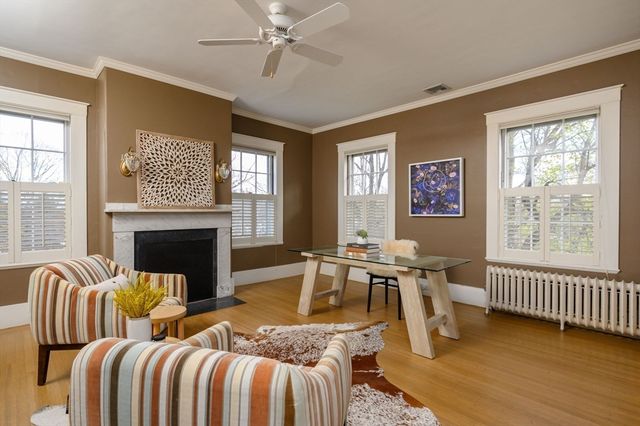 a living room with furniture two windows and a fireplace