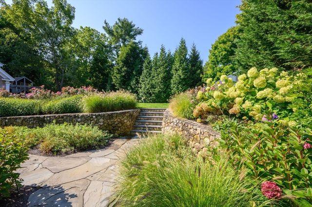 a backyard of a house with lots of green space and outdoor seating