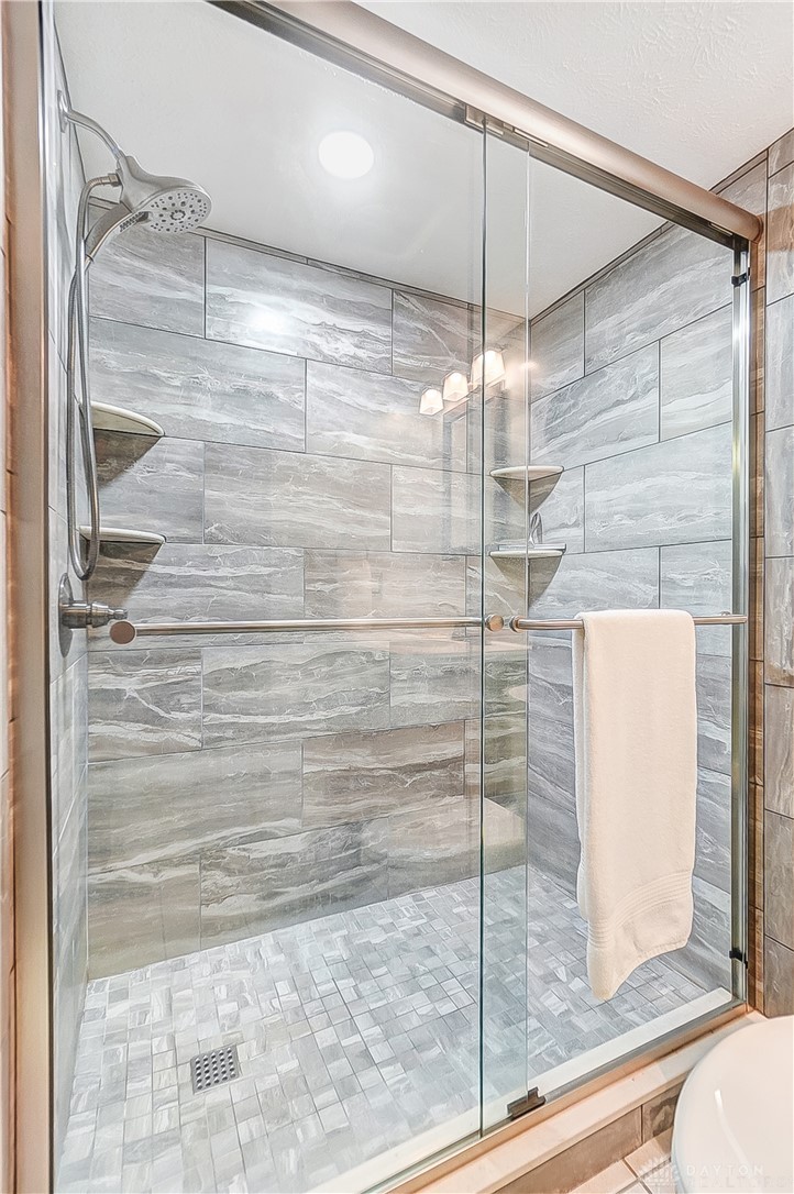1540 Jasper Road Xenia, OH 45385 - Photo 54 of 91 This modern shower features elegant tile work and practical shelving for a refreshing daily routine.