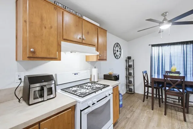a kitchen with a stove a refrigerator and wooden floor