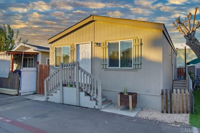 a view of a house with wooden fence