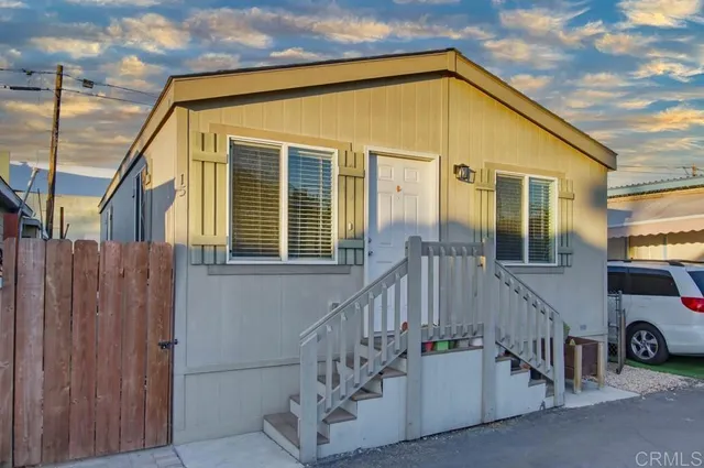 a view of a house with wooden stairs and a small car